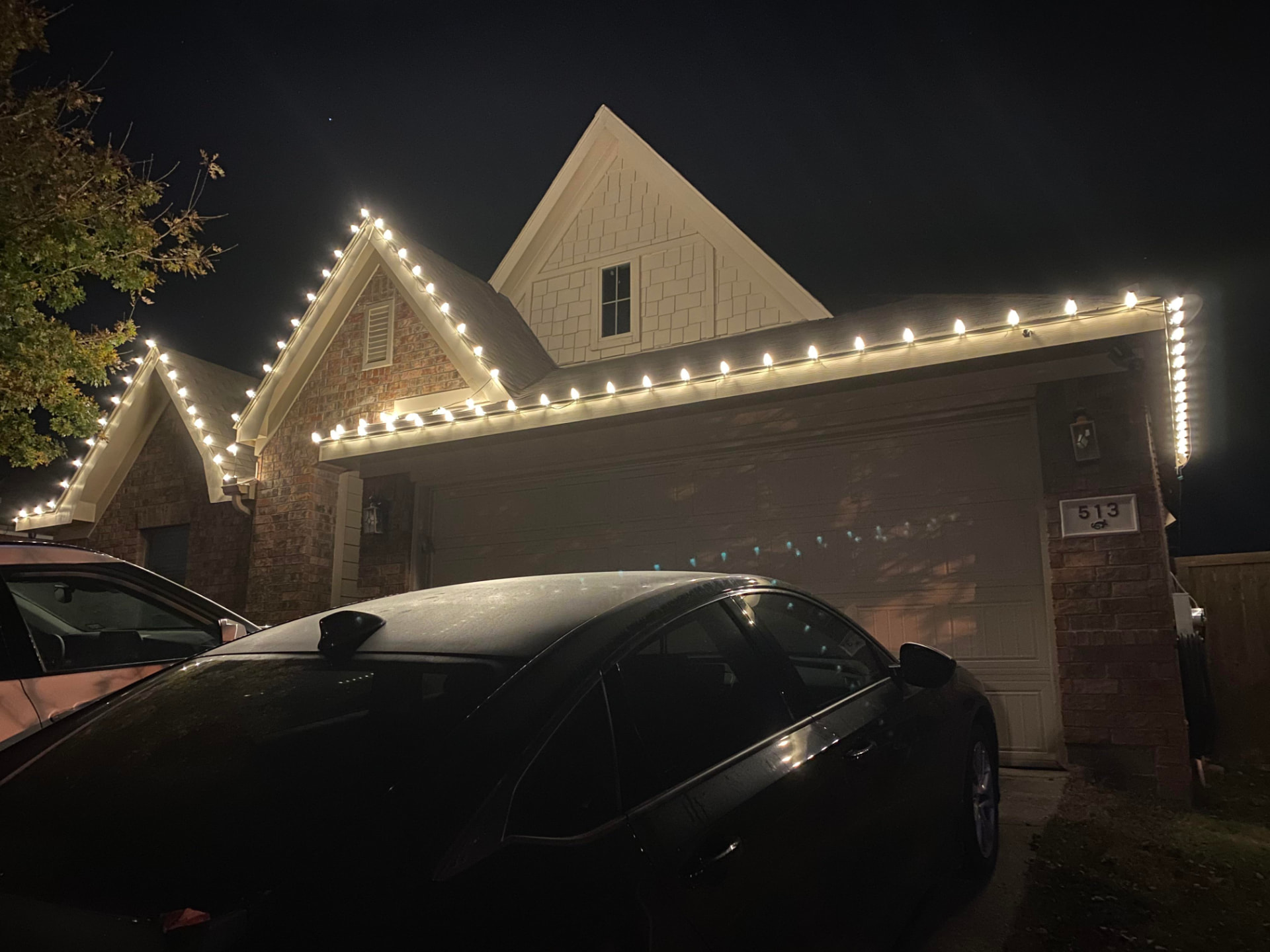 Home with warm white lights along the gables and garage